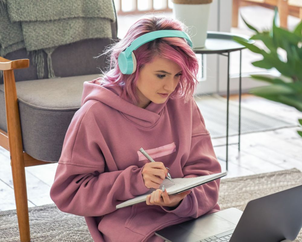 Class in on online school. Teacher talking to student wearing headphones connecting via their laptop.